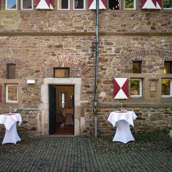 Stehtische am Eingang zu den Tecklenburger Kammern von Schloß Broich