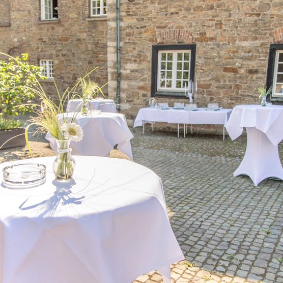Stehtische für einen Sektempfang im Innenhof von Schloß Broich